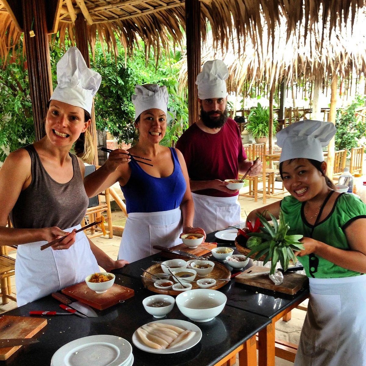 Group of tourists enjoying a meal in Tra Que Vegetable Village, authentic Vietnamese food Hoi An